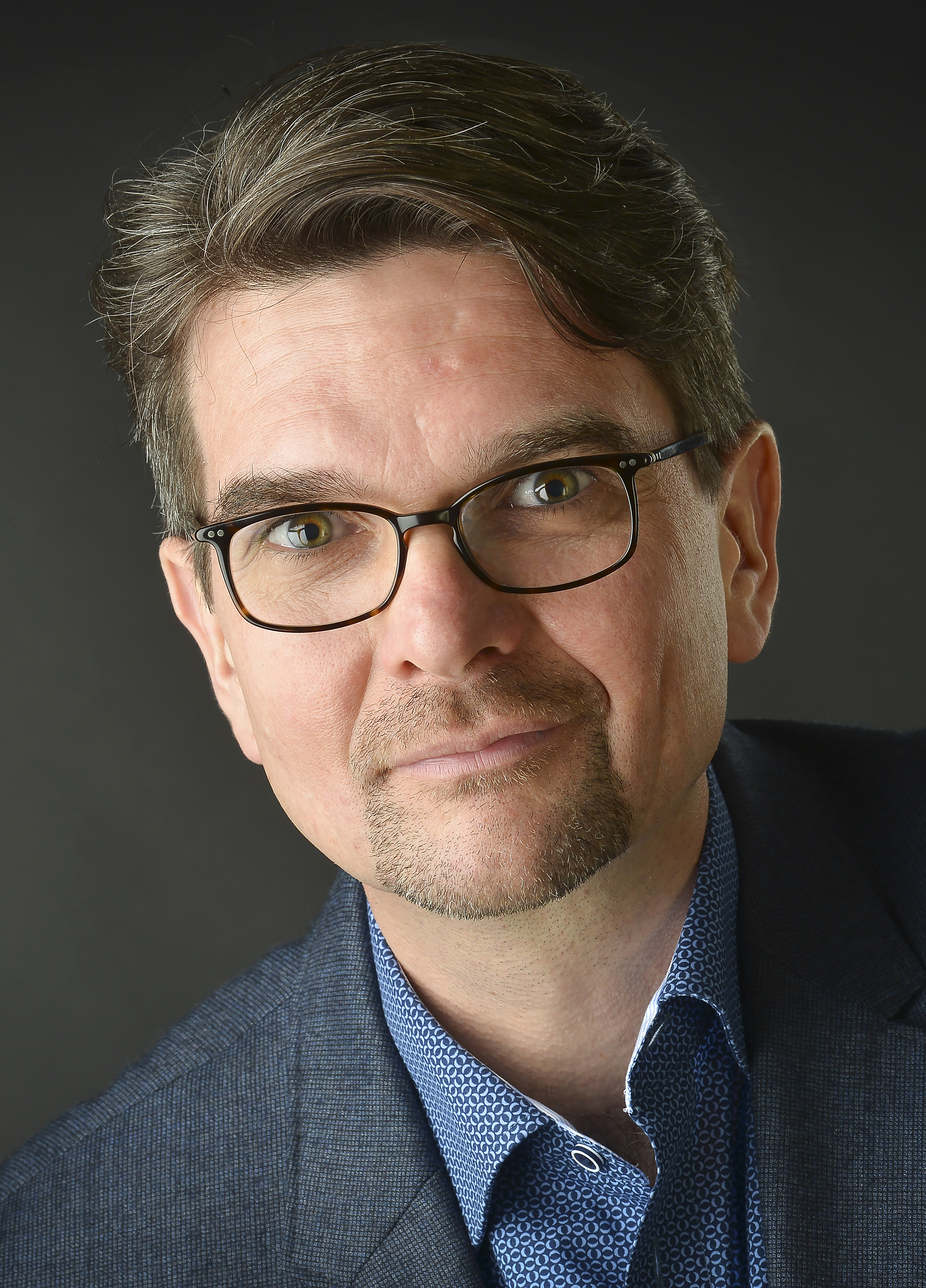 Portrait photo of man with glasses and medium blond short hair