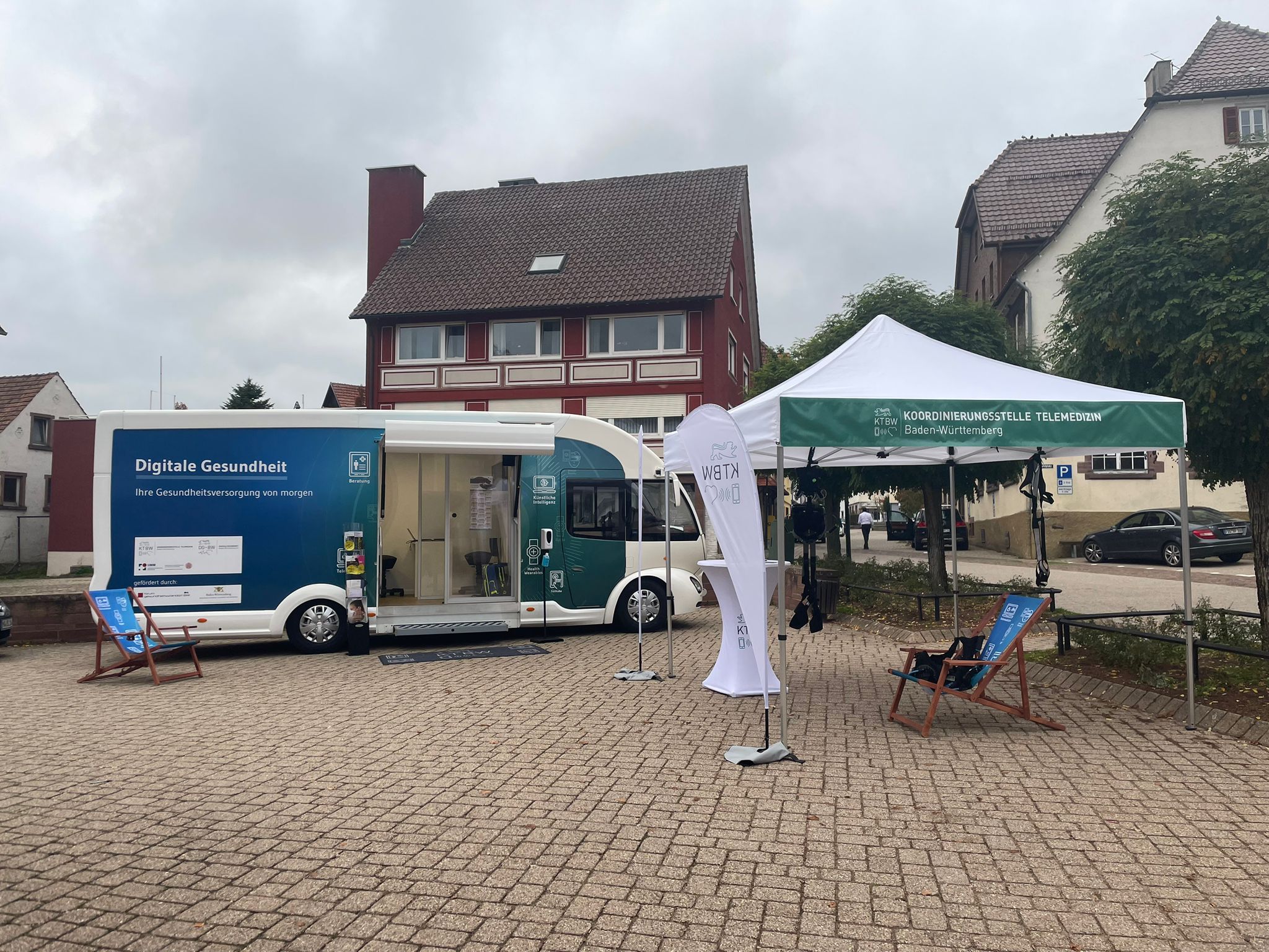 Der Truck steht mit dem Pavillon auf einem Platz vor einem Haus.