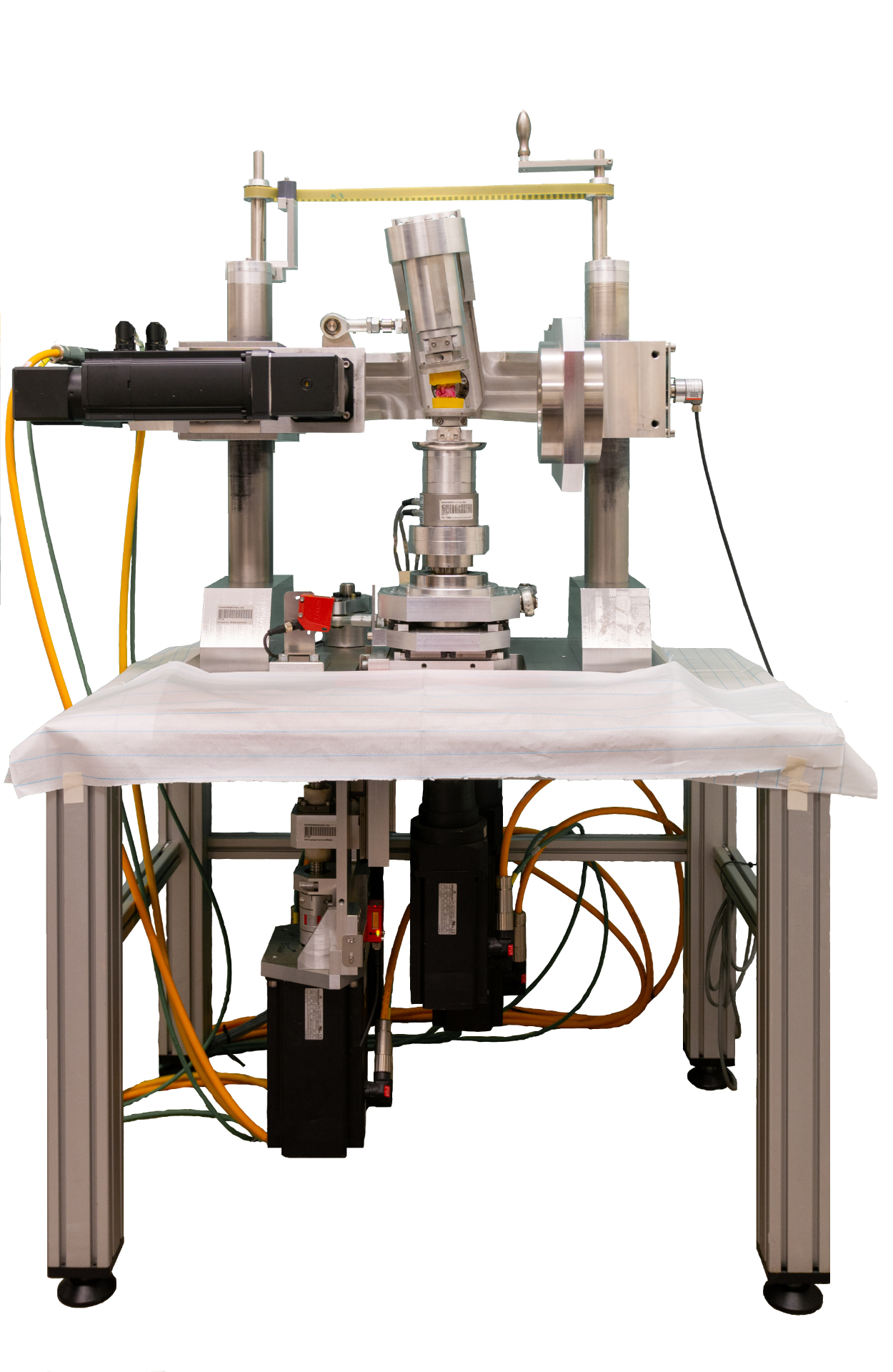 The picture shows the steel and aluminum construction of the spinal load simulator and several electrical cables connected to it.