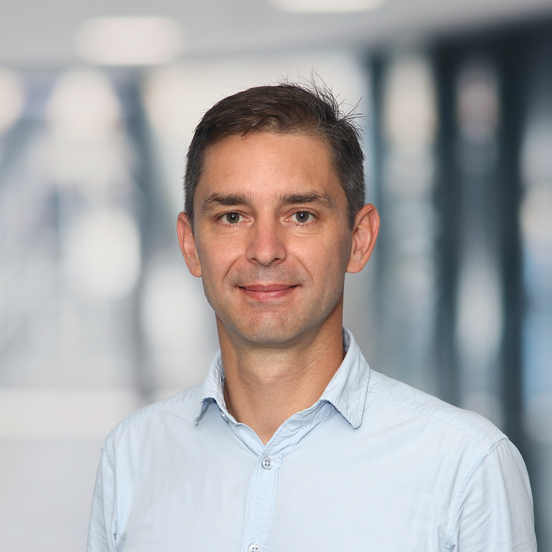 Portrait photo of a friendly looking middle-aged man with short dark blond hair.