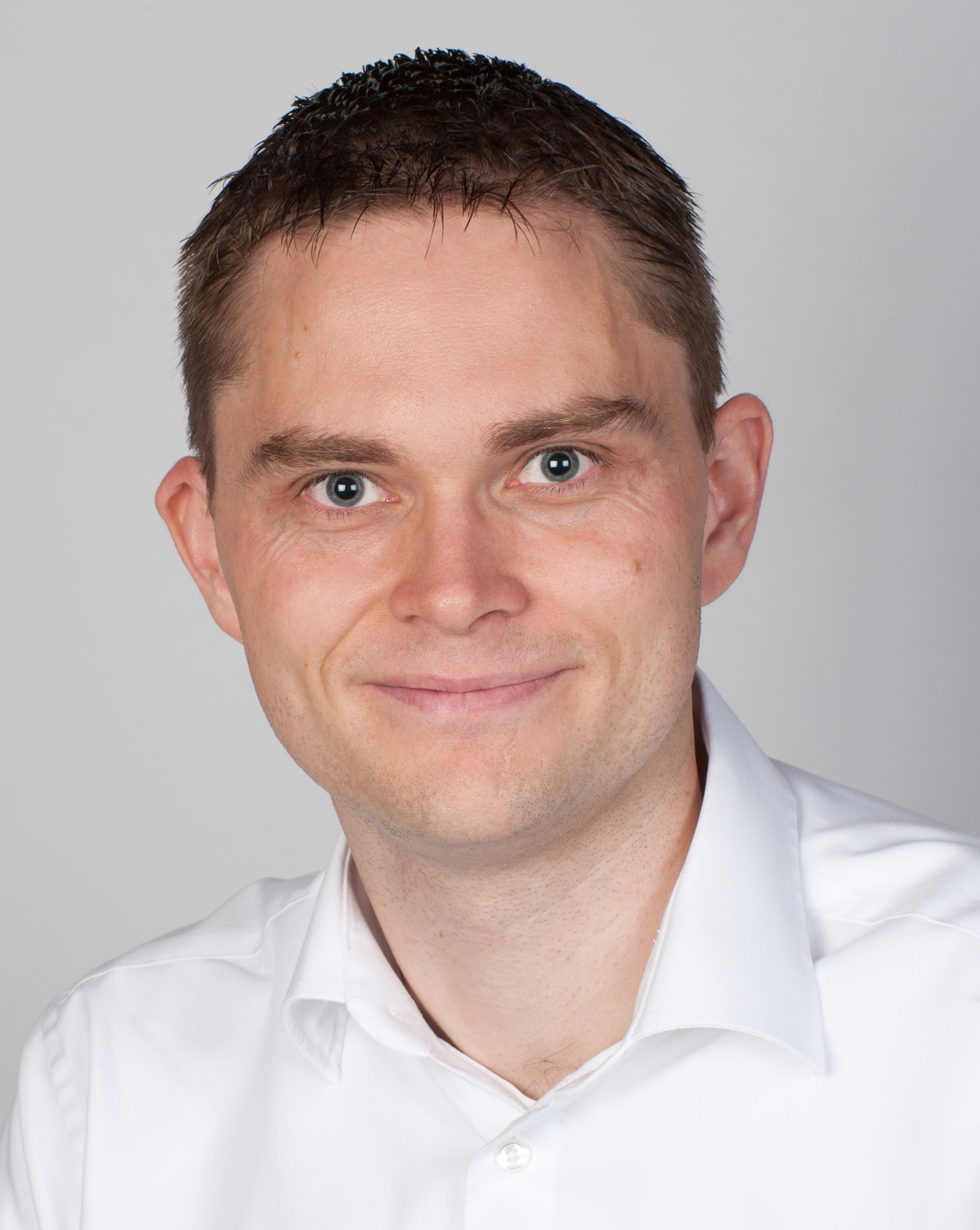 Portrait picture of man with dark hair and white shirt.