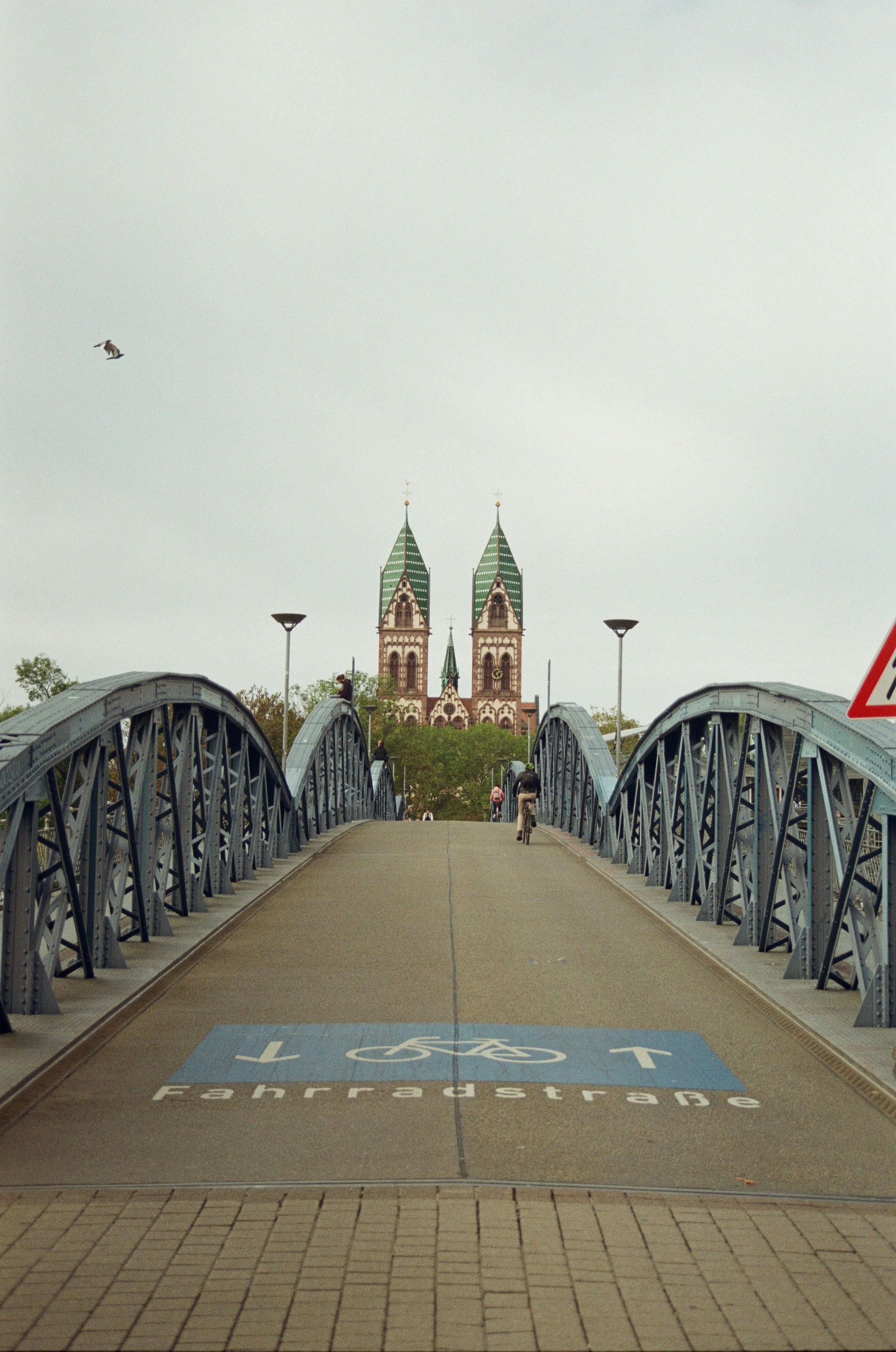 Blick über eine Fahrradstraße in Freiburg, die über eine Brücke führt. Auf der Fahrbahn ist ein Fahrradsymbol mit dem Schriftzug „Fahrradstraße“ zu sehen.