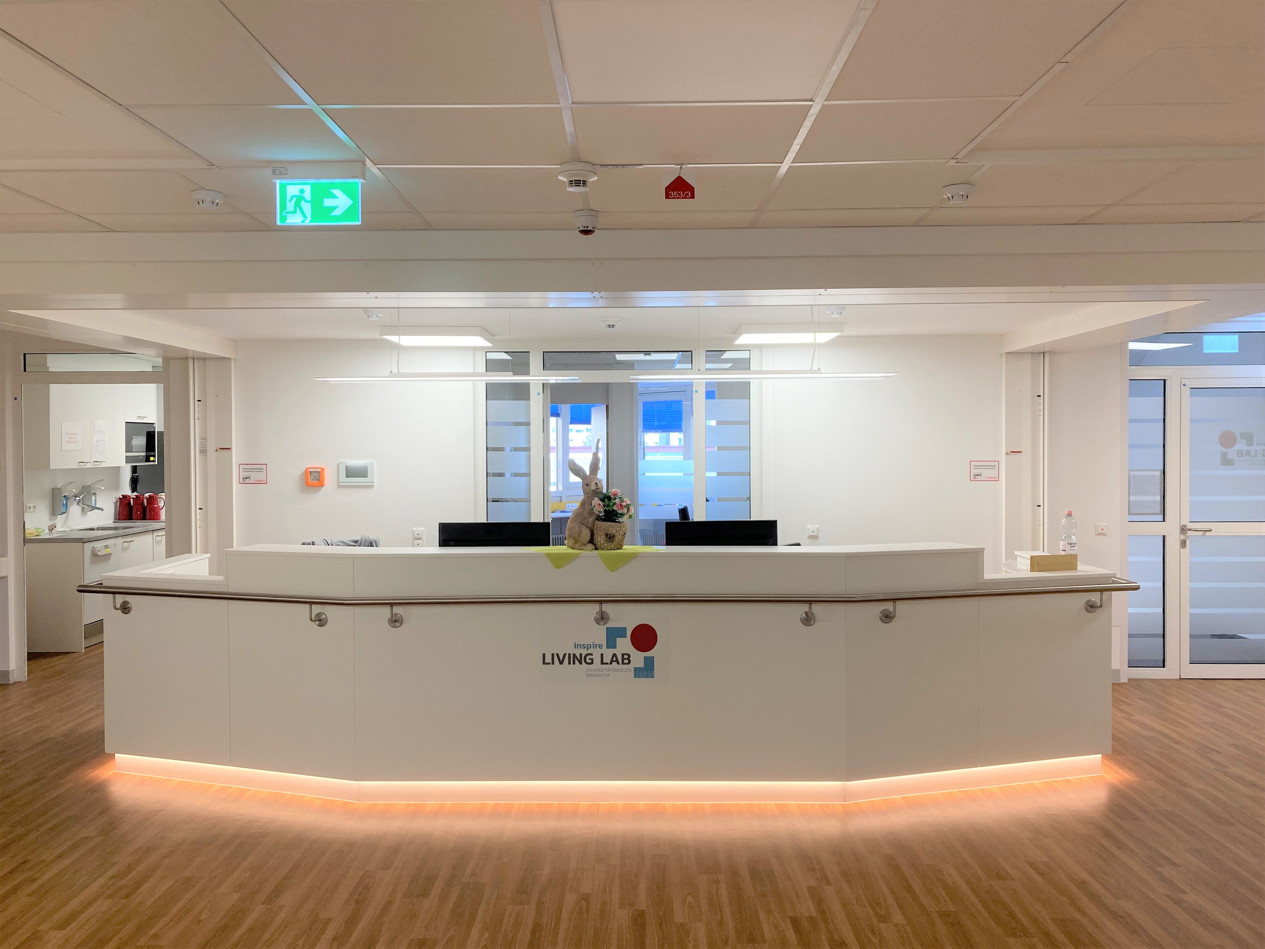 The photo shows a white reception desk in a hospital ward.