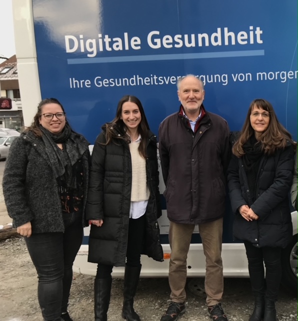 Drei Frauen und ein Mann stehen vor dem Digitale Health Truck