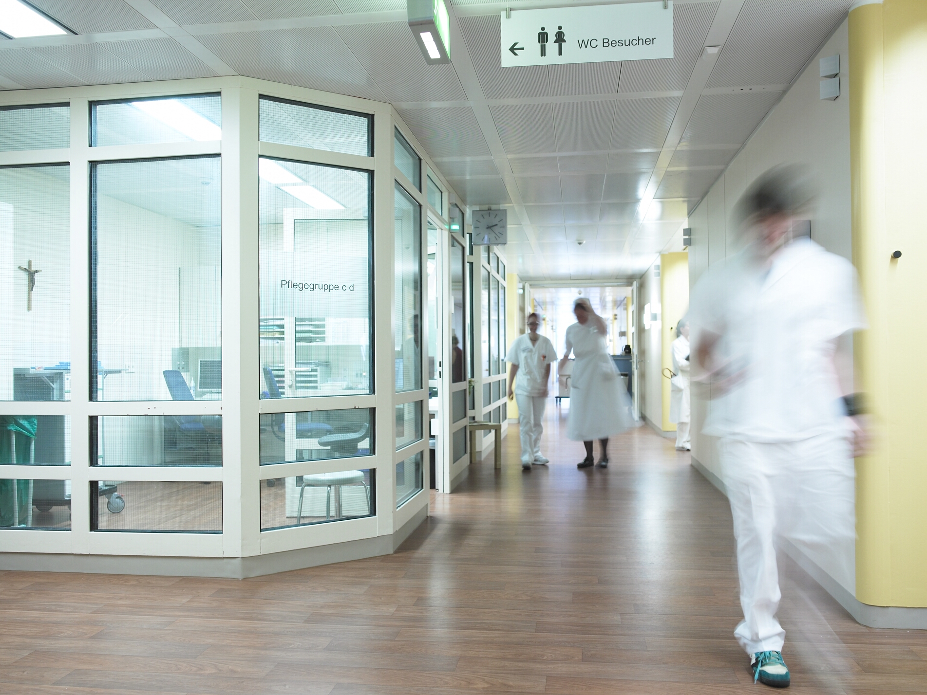 Ein Gang in der Klinik mit drei Pflegekräften.