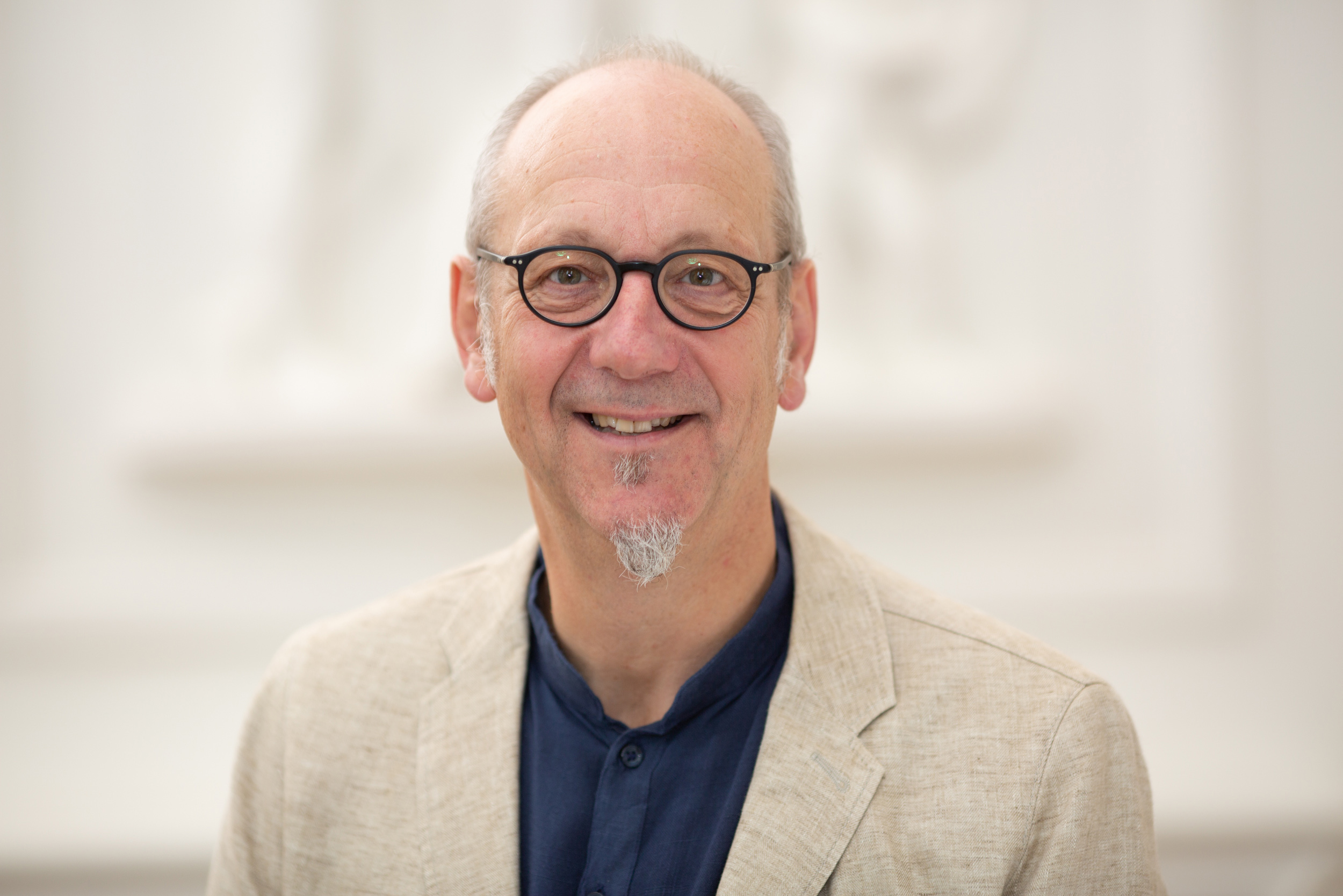 A man with glasses and a short beard can be seen smiling friendly into the camera.