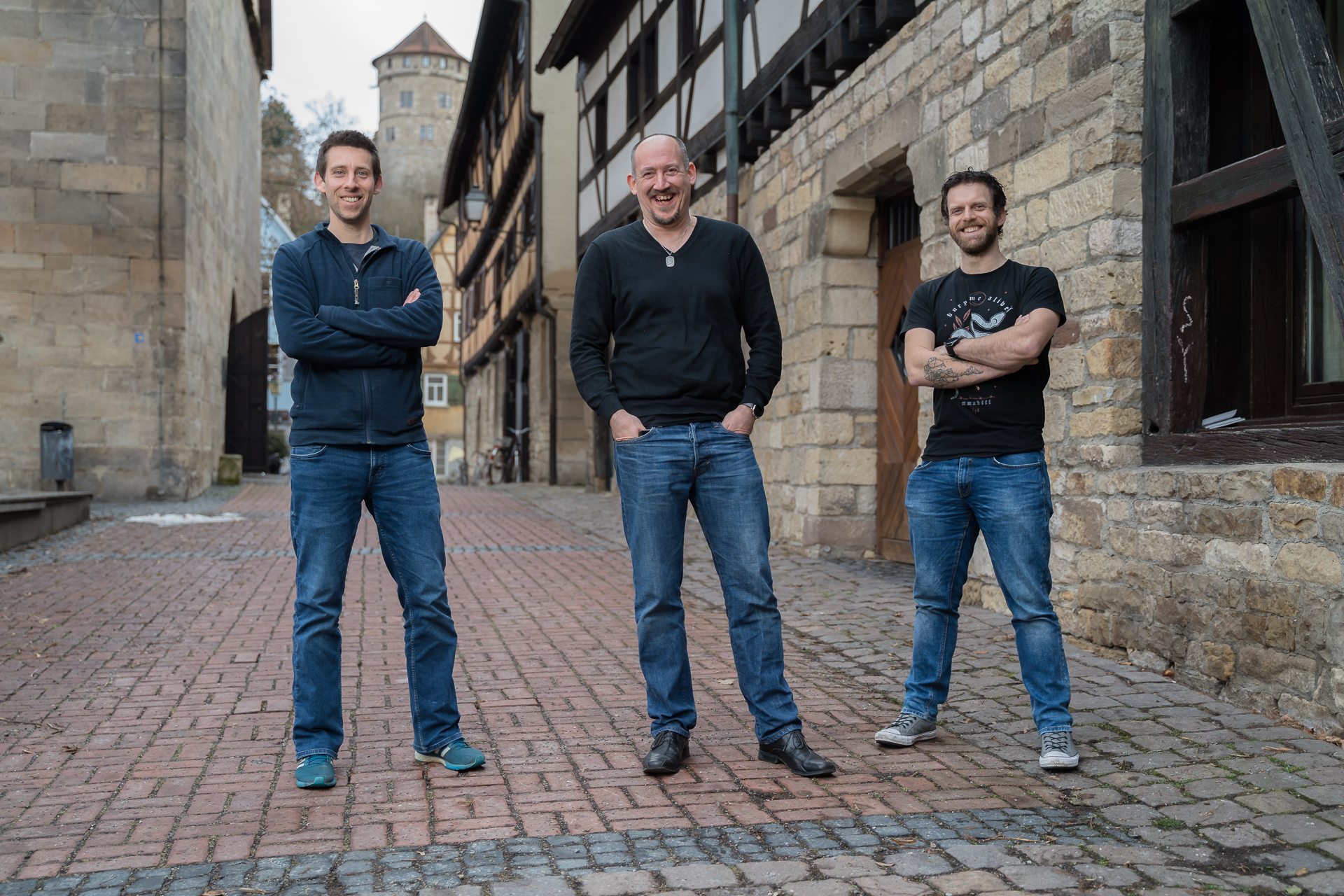 The three artificial intelligence experts are standing on cobblestones in Tübingen's old town.