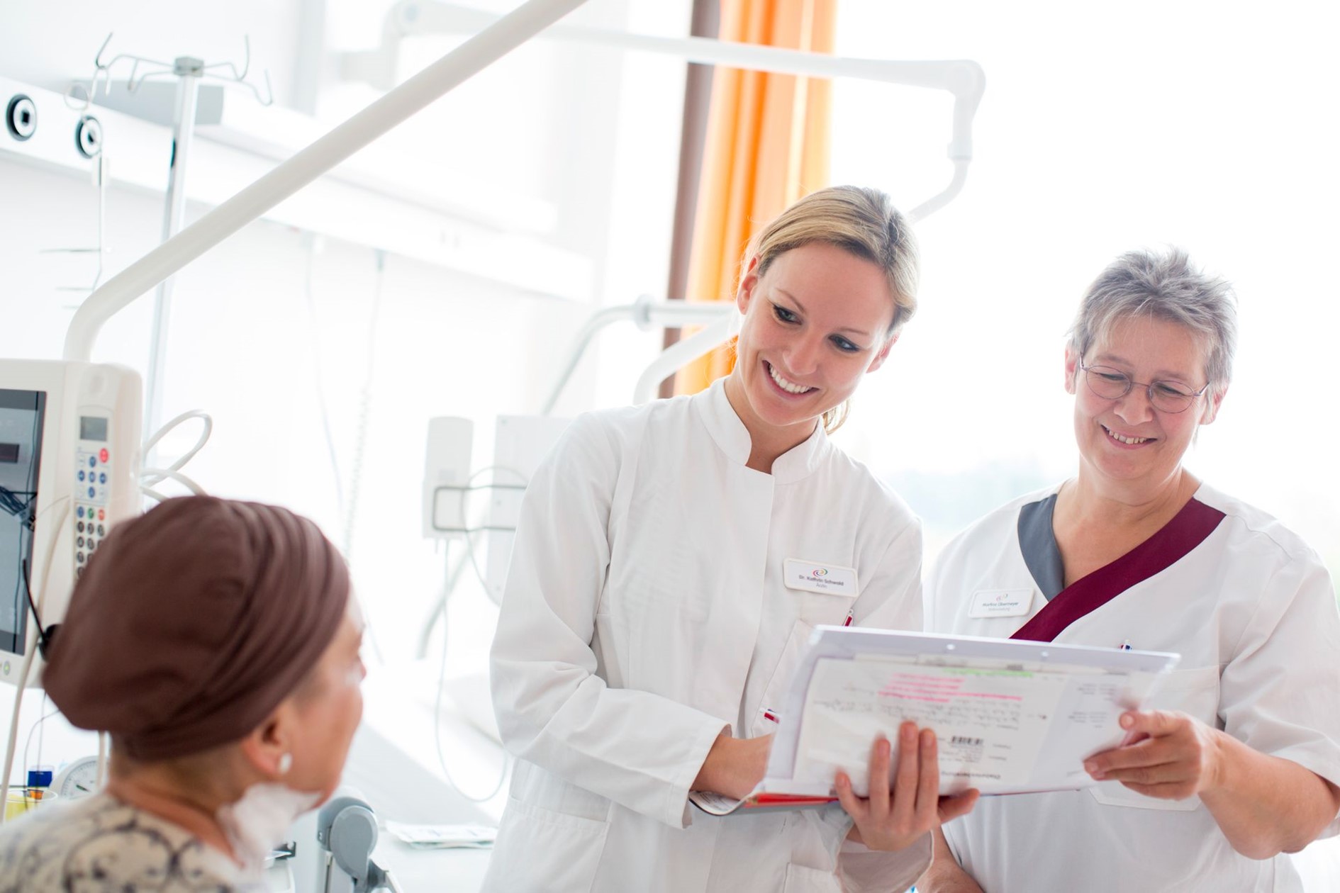 The picture shows a doctor and a nurse of the Schwarzwald-Baar-Klinikum talking to a patient.