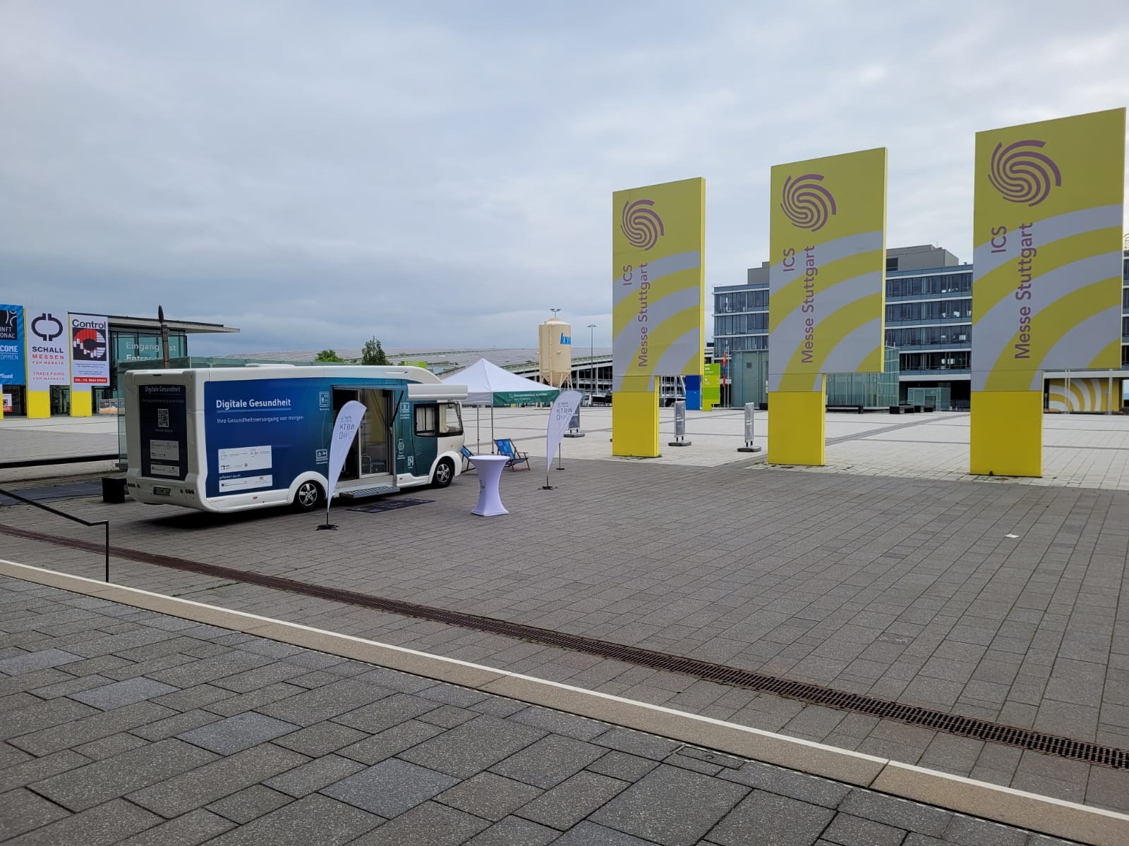 Der Truck steht vor der Messe Stuttgart. Neben dem Truck sind gelb-weiße Schilder zu sehen.