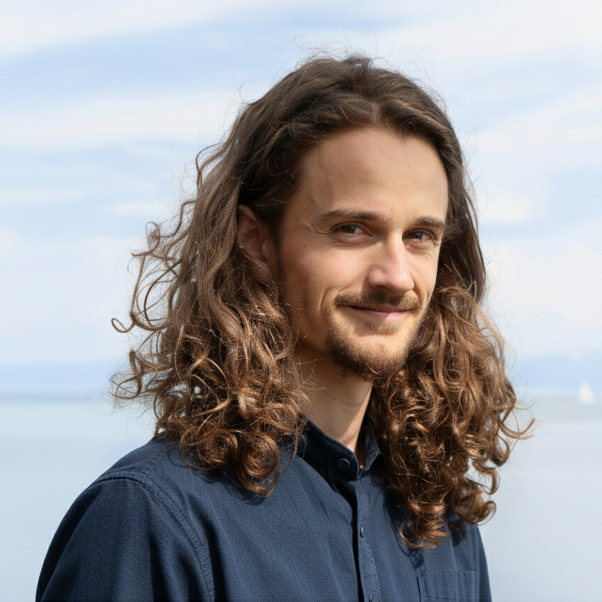 Portrait von Klaus Kestel, einem jungen Mann mit lockigen, langen Haaren, der in Kamera lächelt.