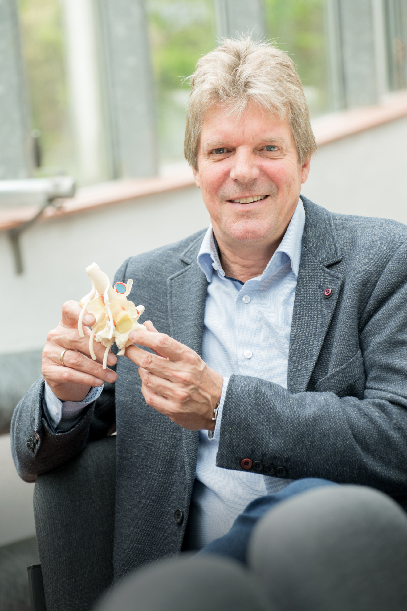 Photo of Prof. Dr. Hans-Joachim Wilke, holding a vertebra in his hands.