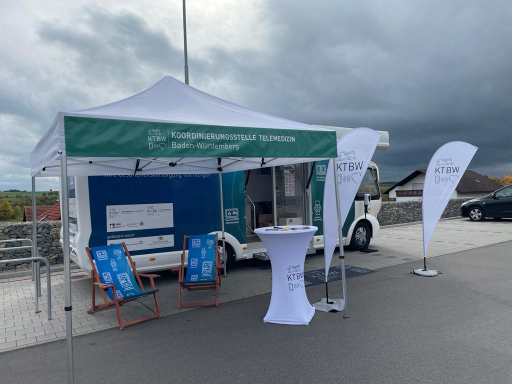 Der Truck mit Pavillon steht vor einem wolkenverhangenen Himmel auf einem Parkplatz.