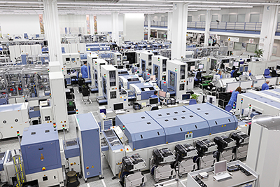Eine Fabrik mit zahlreichen Maschinen, die über Transportbänder oder ähnliches verbunden sind.