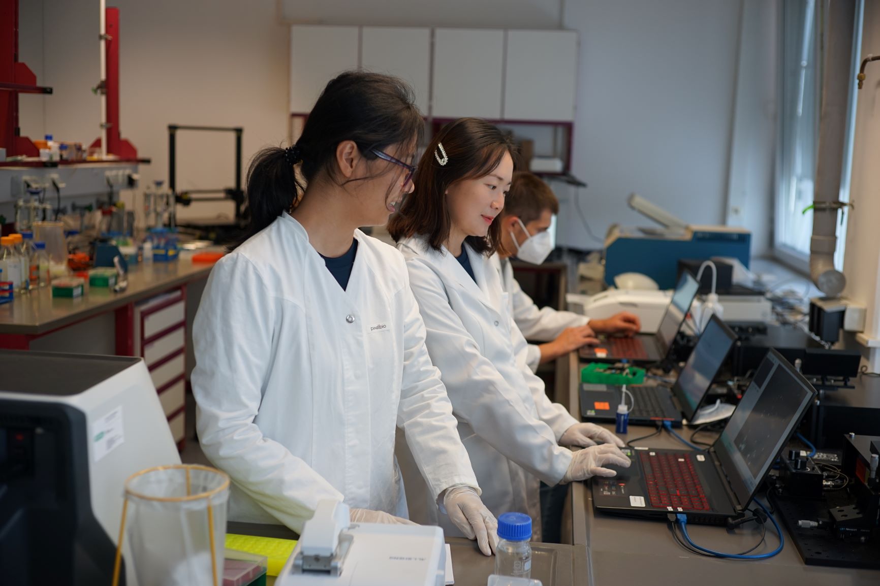 Two staff members carry out data analyses on a notebook in the laboratory.