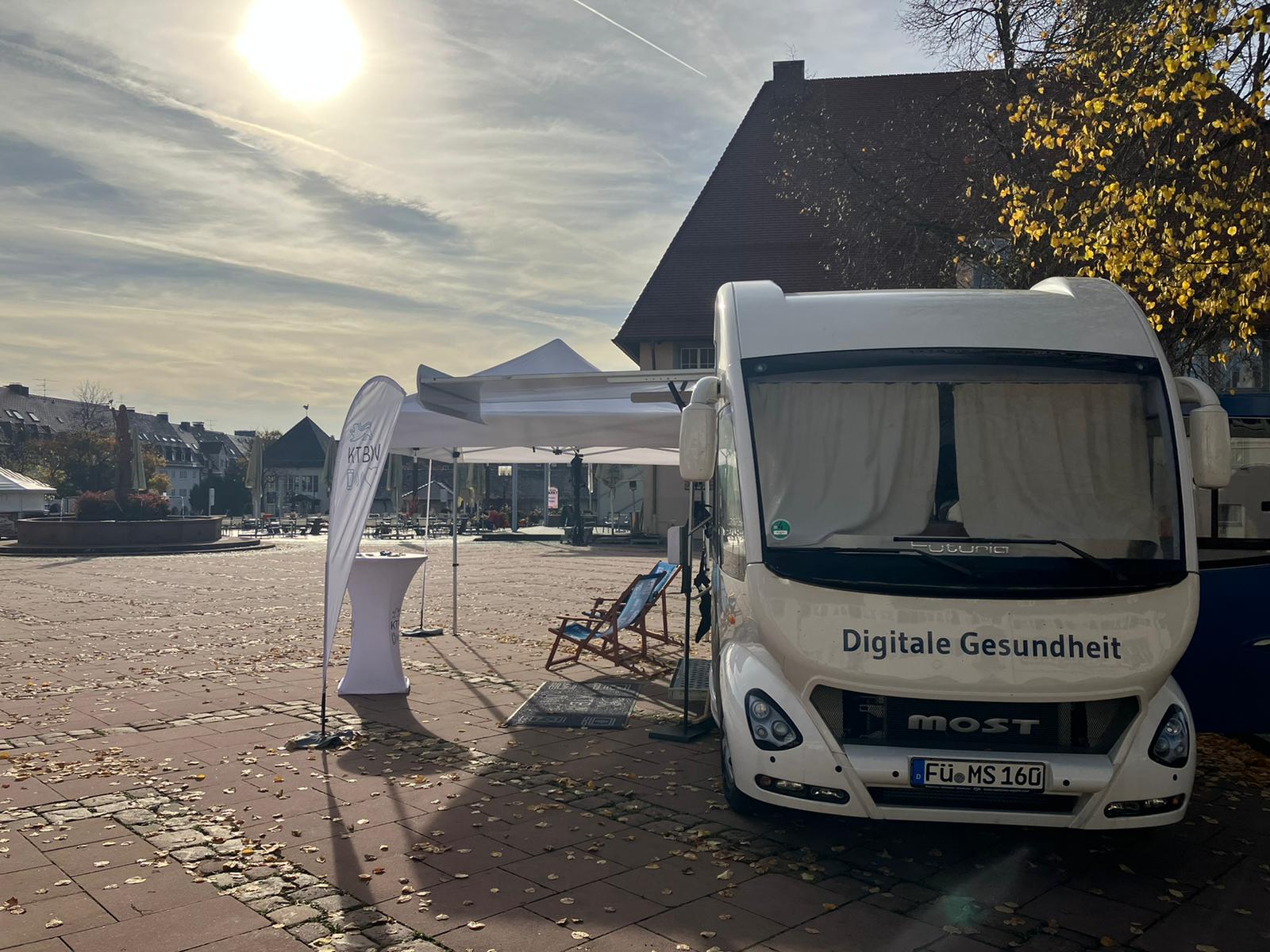 Der Truck steht bei Sonne auf dem Marktplatz. Man sieht die Aufschrift Digitale Gesundheit.