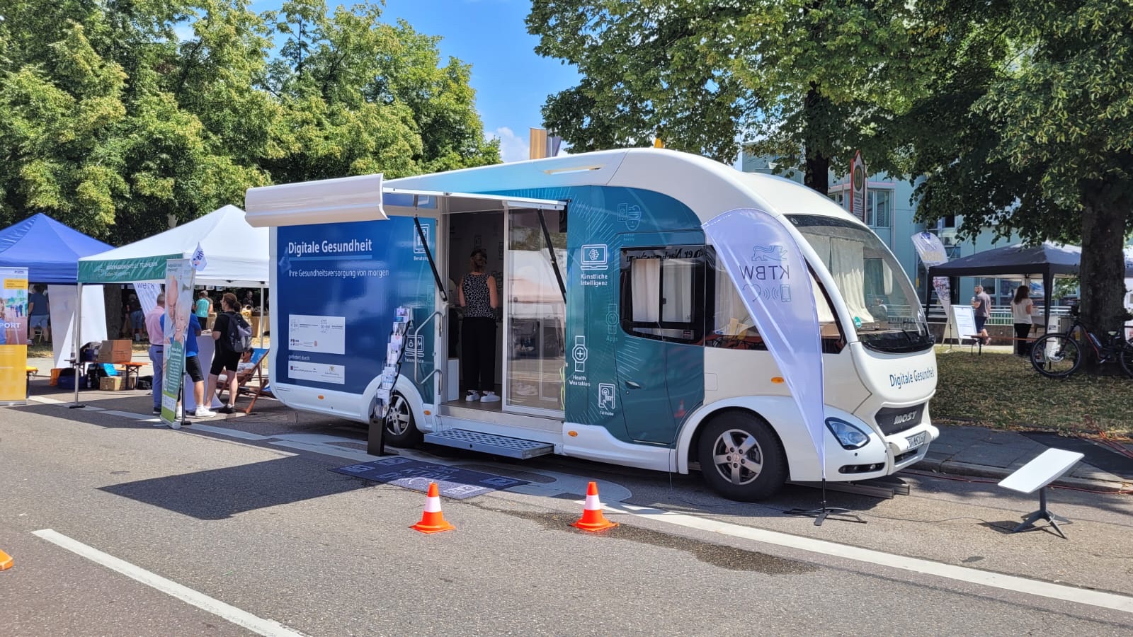 Der Truck steht neben anderen Informationsständen auf einer Straße.