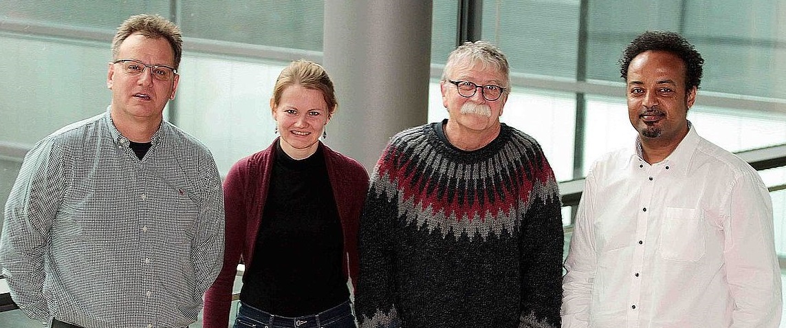 Das Bild zeigt vier Forschende, drei Männer und eine Frau, in Frontalansicht. Die Grundlagenforscher präsentieren sich anlässlich ihrer gemeinsamen Veröffentlichung im hochangesehenen Journal „Blood“.