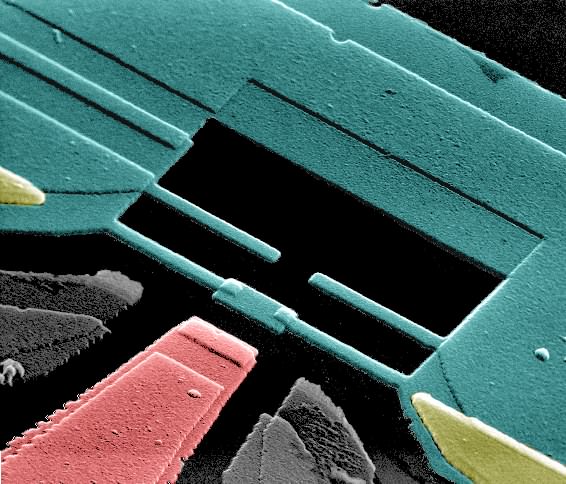 Green, yellow and red coloured structures on a black background. This is a superconducting circuit of a quantum processor.