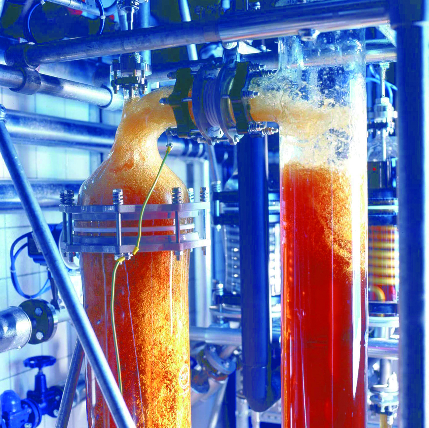 Photo of the extraction procedure used to produce medicinal extracts. Two tube-shaped containers that are connected with each other by other tubes contain a brown liquid. Dr. Willmar Schwabe GmbH & Co. KG uses state-of-the-art methods to produce extracts