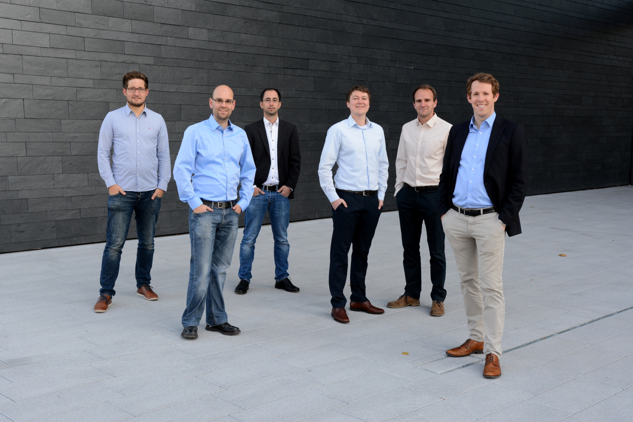 Gruppenbild der sechs Firmengründer in einem Eingang