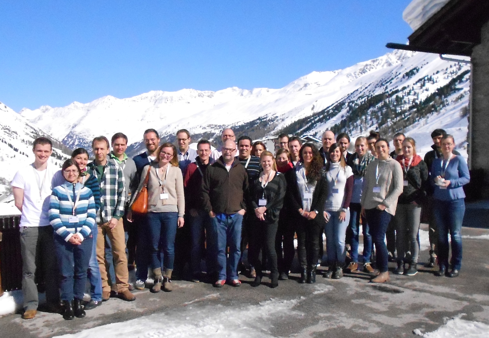The photo shows the members of the international research group standing on a terrace and in front of a mountainous landscape close to the Austrian city of Obergurgl.