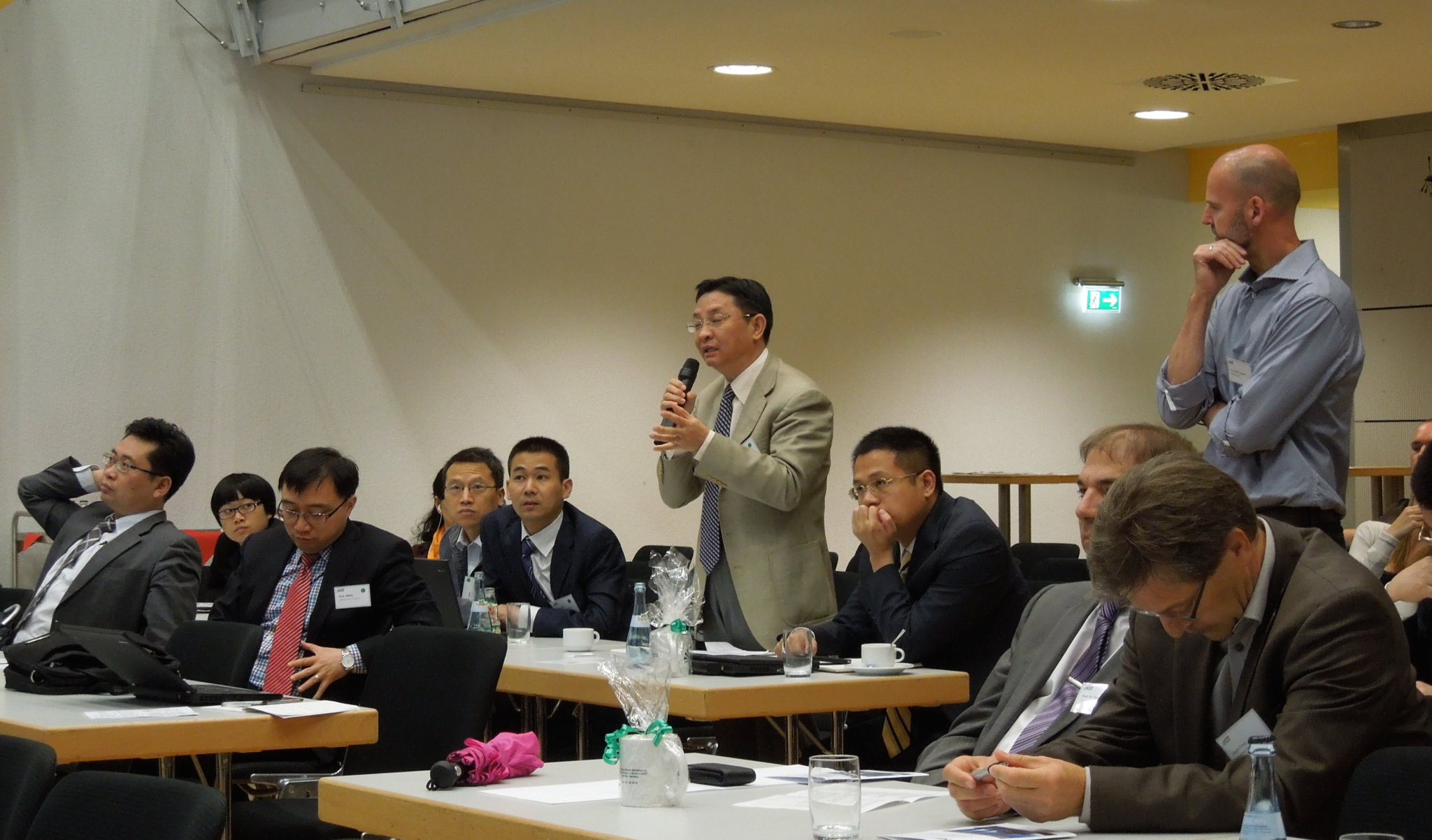 The photo shows Chinese and German workshop participants engaged in a lively discussion.