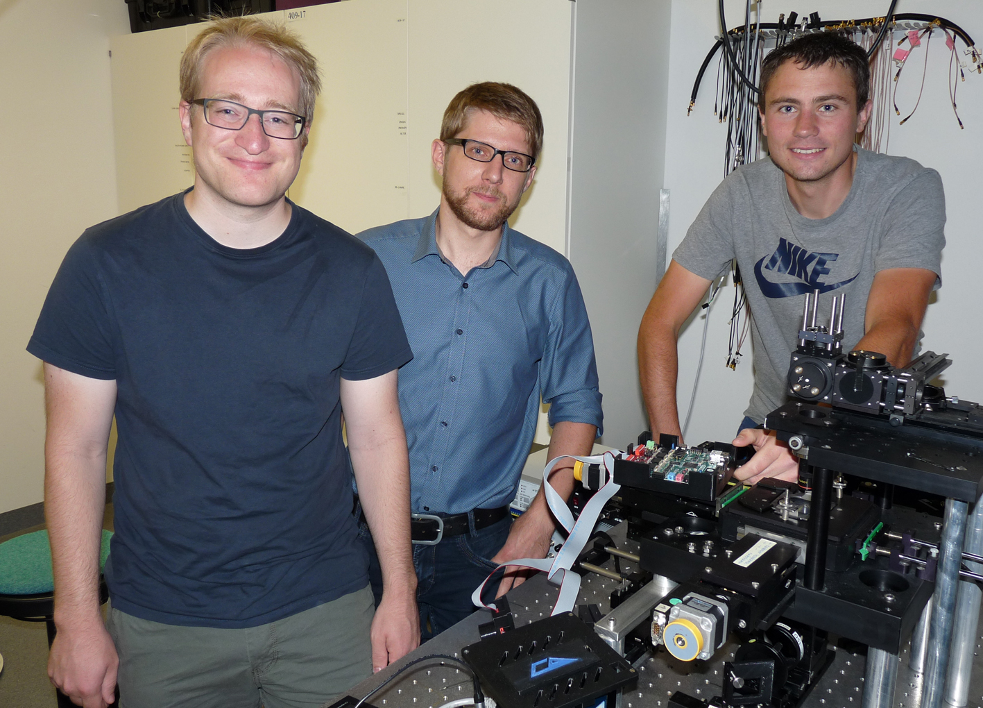 Gruppenfoto des Entwicklerteams (von links nach rechts): Jonas Pfeil, DanielGeiger und Tobias Neckernuß. Rechts im Vordergrund ist eine optischeMessvorrichtung zu sehen. Foto: Daniel Geiger