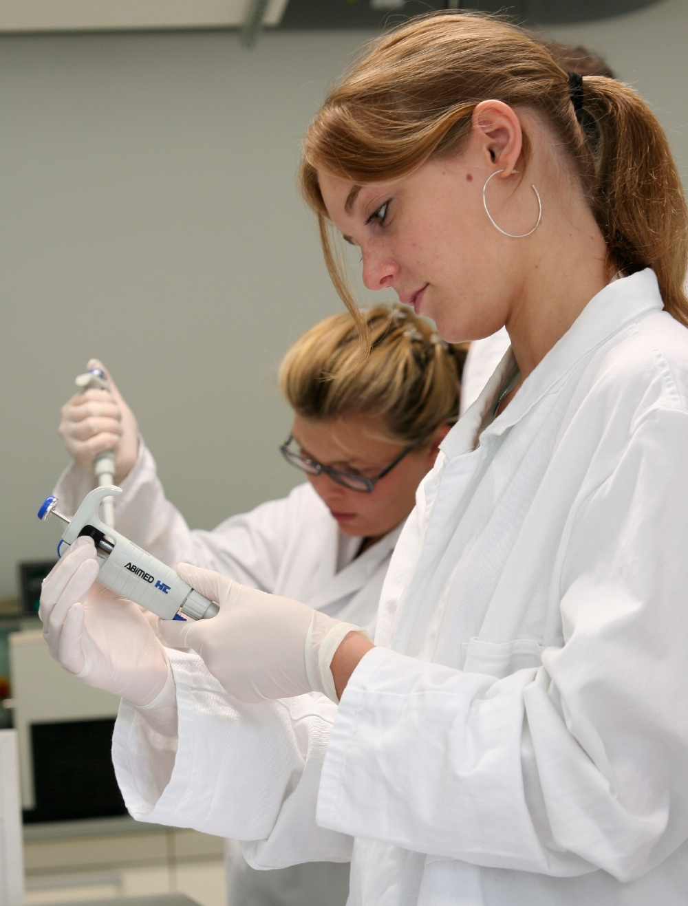 Zwei Schülerinnen beim Pipettieren im Labor.