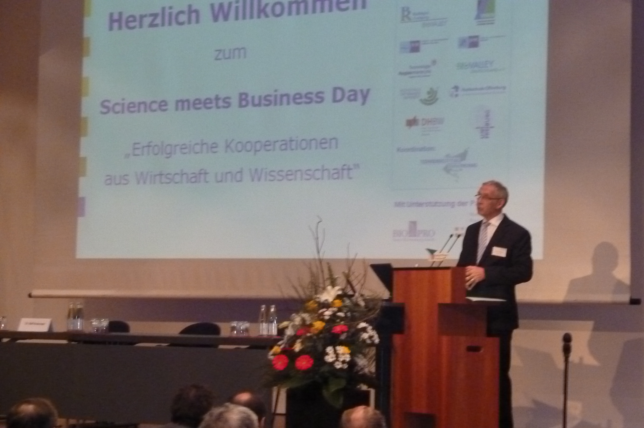 The photo shows Dr. Bernd Dallmann welcoming the audience to the Science meets Business Day in the Freiburg Concert Hall.