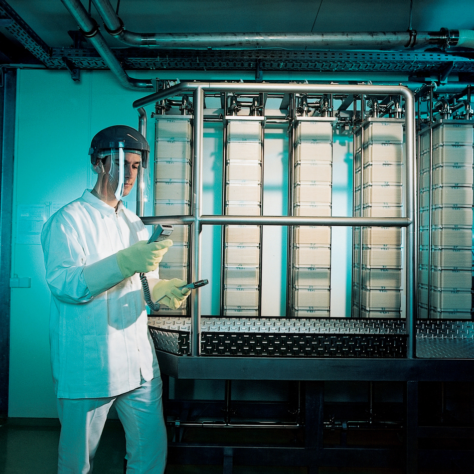 Das Bild zeigt einen Mitarbeiter in einer Downstream Processing Suite bei einem der ersten Aufreinigungsschritte, der Zellernte, die hier mittels Mikrofiltration geschieht.