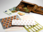 The photo shows different tablet packages and an open wallet mit coins and banknotes.<br />