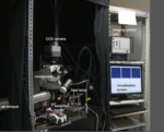The photo shows the experimental set-up used to analyse olfactory processes in bees. In includes a microscope, a camera, a CCD camera and a screen.<br />