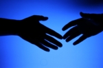 Zwei schwarze Hände auf blauem Hintergrund, symbolische für "Wissenschaft trifft Management"