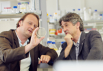 The photo shows Andreas Marx and Martin Scheffner in the laboratory and evaluating a Petri dish.