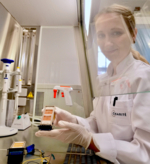Wissenschaftlerin im Labor an einer Zellkultur-Arbeitsbank mit einer Zellkammer