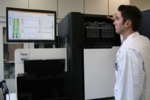 The photo shows a next-generation sequencer consisting of a sequencing unit and a desktop computer.