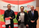 Scherle, Stier und Baringhaus bei der Preisvergabe. Die Urkunde sowie der Preis wird gezeigt.