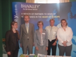 The photo shows five people standing in front of a board with the title "BioValley".