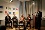Vier Menschen diskutieren auf einem Podium.