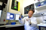 Prof. Dr. Marcus Groettrup im Labor mit Pipette und Reagenzglas in den Händen.
