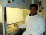 Dr. Mardas Daneshian im Labor sitzend mit Probengefäß in der Hand.