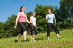 Drei Frauen befinden sich auf einer Wiese und treiben Sport.
