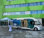 Dr. Armin Pscherer steht im Eingangsbereich des Trucks. Der Truck steht vor einem grünem Gebäude (Forschungsgebäude N27) der Universität Ulm.