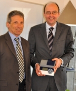 Klaus Haberstroh, CEO der ESE GmbH und Dr. Michael Collasius, Vice President Automated Systems der QIAGEN Instruments AG, der eines der ESE-Messgeräte in der Hand hält.