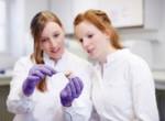 Zwei Wissenschaftlerinnen im Labor, die die künstliche Herzklappe in der Hand halten und betrachten.