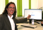 The photo shows Johannes Englert, pointing towards the online login page of the Baden-Württemberg Cancer Register.