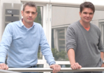 The photo shows two men standing at a balustrade