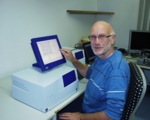 Dr. Hanswilly Müller bedient den blau umrahmten Touchscreen-Monitor der CLAIR-Maschine.