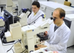 Zu sehen sind zwei Wissenschaftler beim Mikroskopieren.