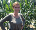 Frau Prof. Timmerman steht vor einem Maisfeld.